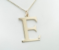 Duża złota literka E z brylantem