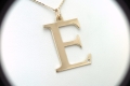 Duża złota literka E z brylantem