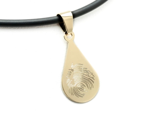 Złota łezka z odcieskiem palca